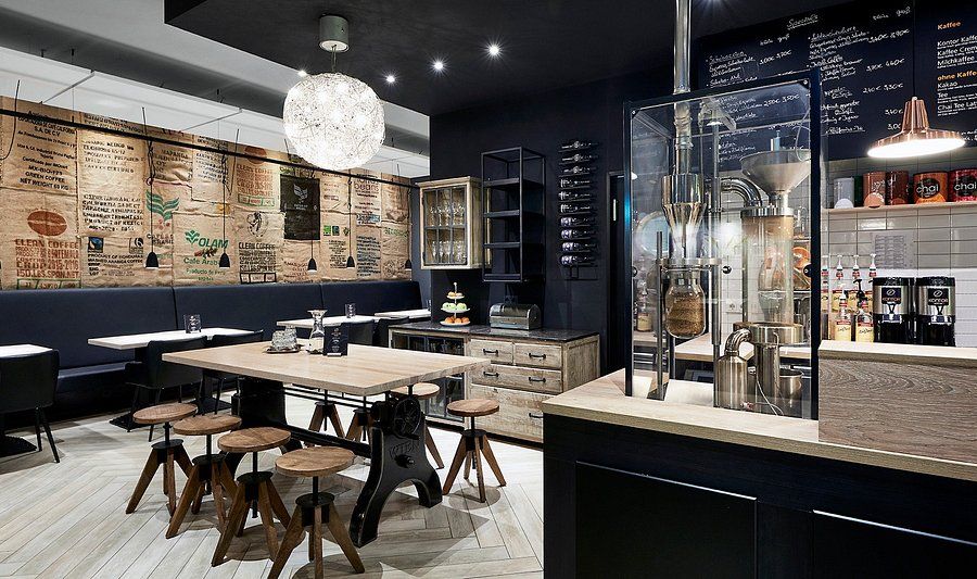 Modernt kaféinteriör med kaffesäcksvägg, bänkar och bord, som en lounge på kontorshotell.